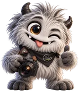 Cajo, das Maskottchen von Schütz Fotografie, hält eine Kamera und freut sich